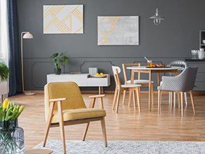 Grey modern dining setting with yellow chair timber floor and table with plants grey chair